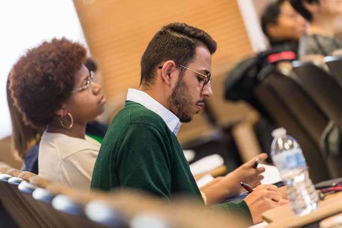 A man focuses on work in a classroom setting.	