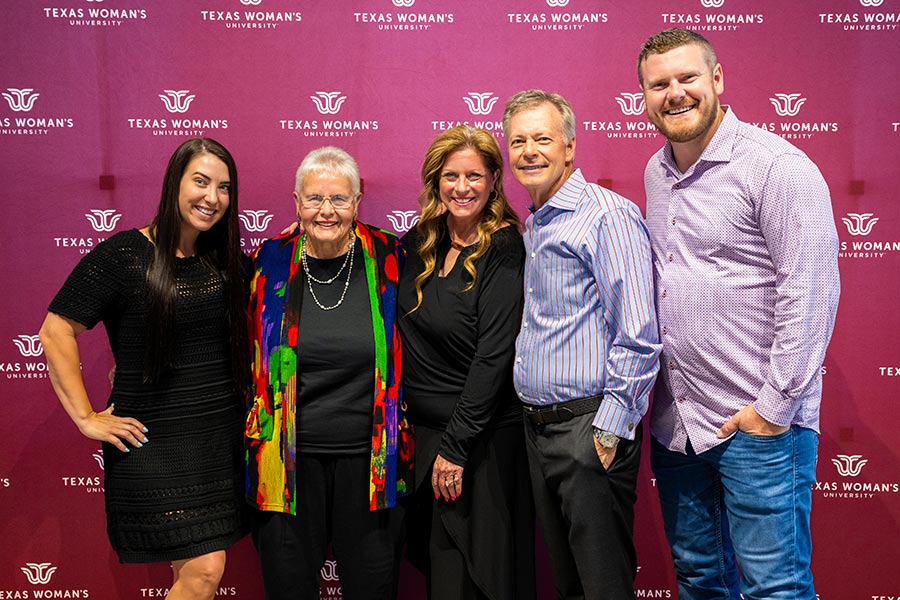 Five members of the Kick family stand in front of a TWU backdrop
