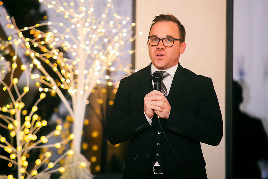 Awstin Gregg, TWU MBA grad, holds microphone in conference room 