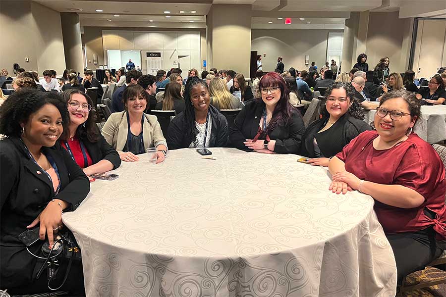 seven members of AMA chapter sit around a round table in a conference room