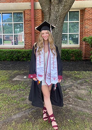 TWU student Brooke Speights stands outside in her graduation attire