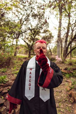 Andy Hackett in his graduation gown and the Oakley mascot arms on.