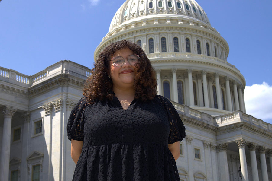 Karyme Flores stands in front of the US Congress building on a sunny day.