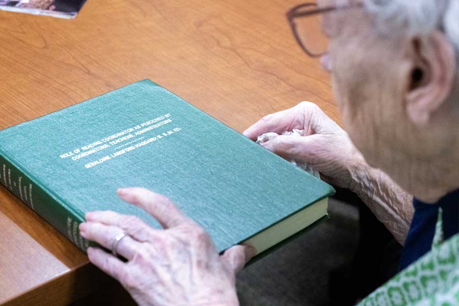 Haggard peruses her printed and bound dissertation from 1980: Role of Reading Coordinator as Perceived by Coordinators, Teachers, Administrators