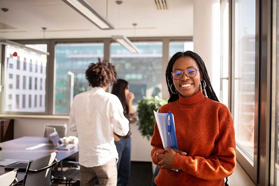 A woman in professional attire in an office setting at an internship.