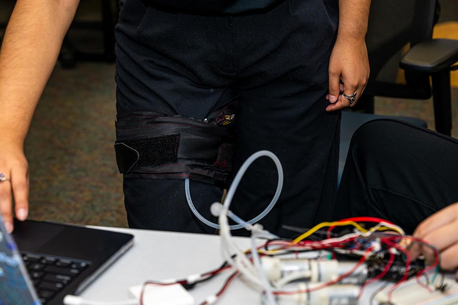 a blood restriction cuff is strapped on a person's thigh with wires running to it