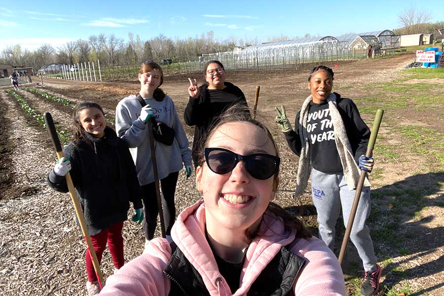 a student takes a selfie with four students in background