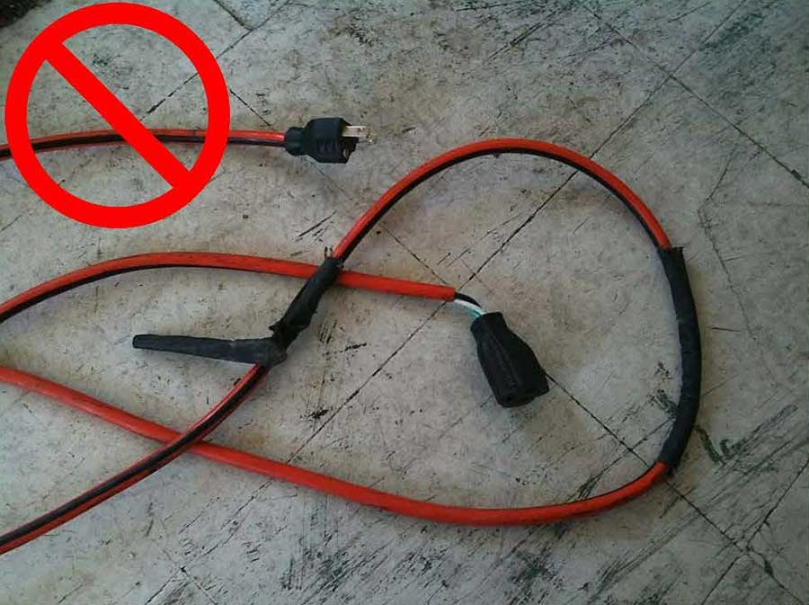 A taped and damaged cord where insulation has pulled out of the plug