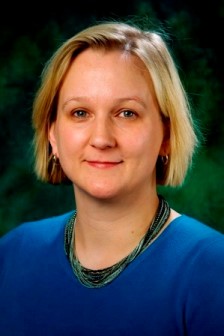 A portrait photo of Sian Brannon. She has short blonde hair and is wearing a blue sweater.