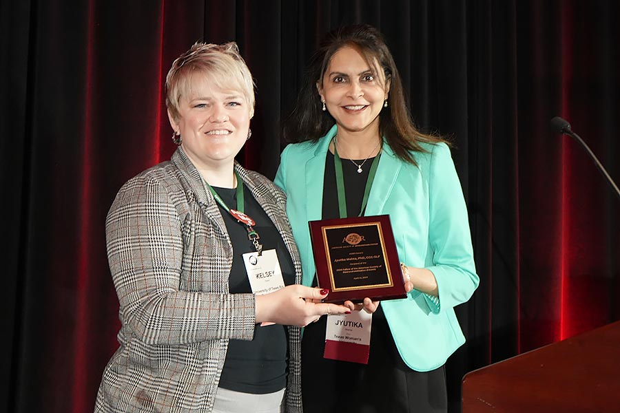 Jyutika Mehta holds plaque alongside staff member