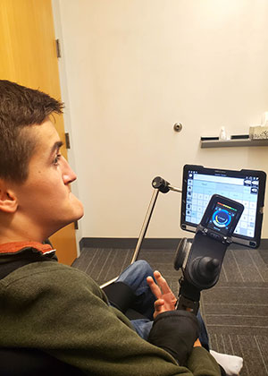 Watson Polk sits in a SLP session with his computer screen in front of him